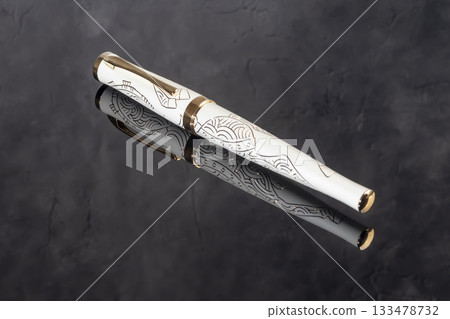 A branded fountain pen next to a box. Gift set. Selective focus. Office interior 133478732