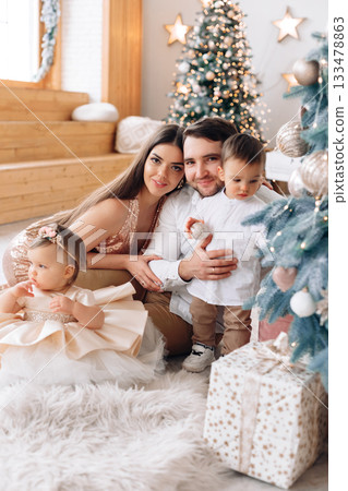 Family gathering at home during holiday season with a festive atmosphere and a beautifully decorated Christmas tree Family gathering at home during holiday season with a festive atmosphere and a beautifully decorated Christmas tree 133478863