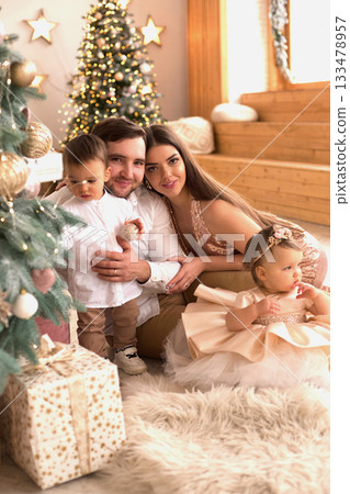Family celebration with children during festive season at cozy indoor setting with decorative tree and gifts Family celebration with children during festive season at cozy indoor setting with decorative tree and gifts 133478957