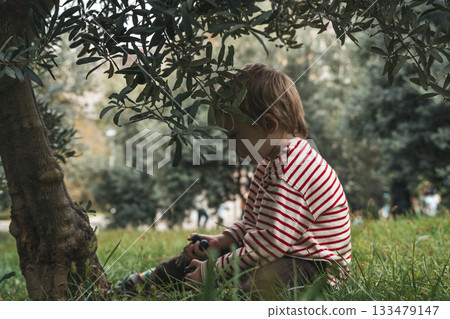 Child boy Under Olive Tree. Childhood in Nature Child boy Under Olive Tree. Childhood in Nature 133479147
