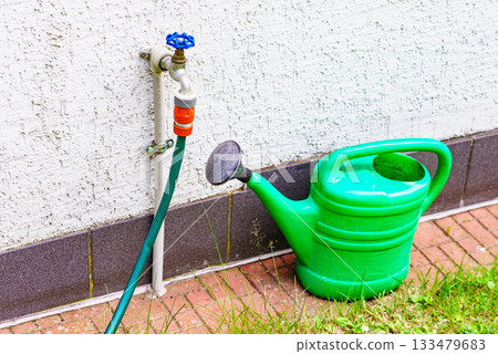 Watering green can on garden plot Watering green can on garden plot 133479683