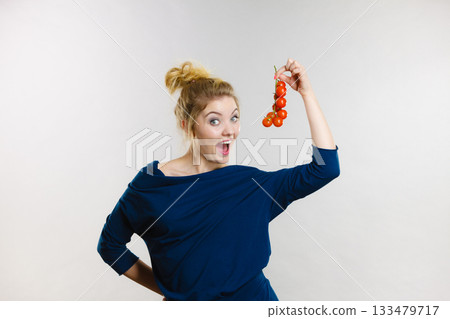 Woman holding fresh cherry tomatoes Woman holding fresh cherry tomatoes 133479717
