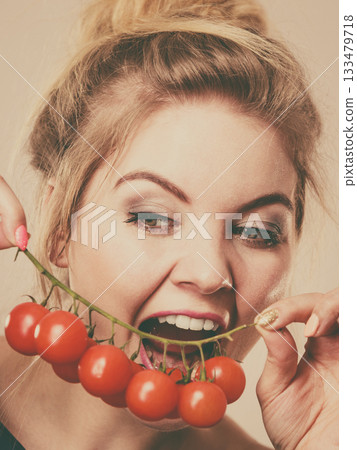 Woman holding fresh cherry tomatoes Woman holding fresh cherry tomatoes 133479718