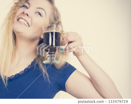 Positive woman drinking her morning coffee Positive woman drinking her morning coffee 133479729