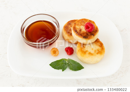 Curd fritters with raspberries and honey. Curd fritters with raspberries and honey. 133480022