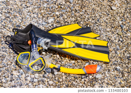 Flippers and snorkeling tube on sea shore Flippers and snorkeling tube on sea shore 133480103