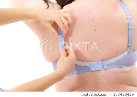 Bra fitter help plus size woman find perfect fit. Back view. Bra fitter help plus size woman find perfect fit. Back view. 133480439