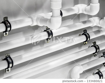 Pipes installed on a wall for plumbing system in modern building 133480821