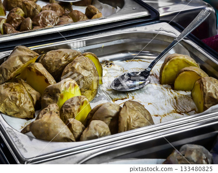 Freshly cooked baked potatoes served on a tray at a buffet setting in the dining area of a community event 133480825