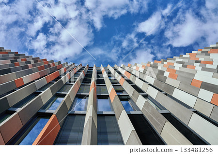 Modern office building facade with geometric pattern against blue sky Modern office building facade with geometric pattern against blue sky 133481256
