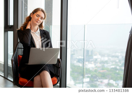 Young caucasian businesswoman tired and neck pain and muscle ache while using laptop. Young caucasian businesswoman tired and neck pain and muscle ache while using laptop. 133481386