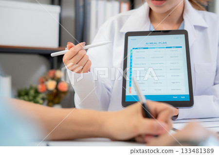 Close up nutritionist using tablet to explaining personalized meal plan with AI to patient. Close up nutritionist using tablet to explaining personalized meal plan with AI to patient. 133481389
