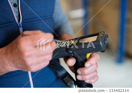 Older male warehouse worker or a supervisor holding barcode scanner. Older male warehouse worker or a supervisor holding barcode scanner. 133482214