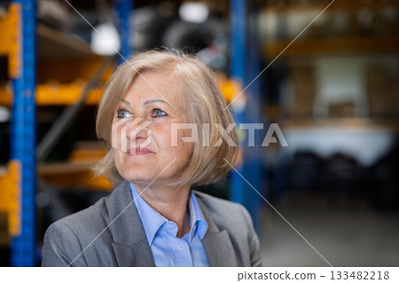 Senior woman warehouse manager or supervisor , arms crossed. 133482218