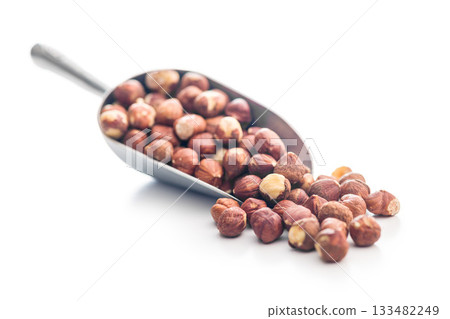 Peeled hazelnut kernels in scoop isolated on white background. Peeled hazelnut kernels in scoop isolated on white background. 133482249