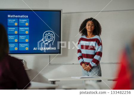Teen girl presenting AI learning project in classroom. Teen girl presenting AI learning project in classroom. 133482256