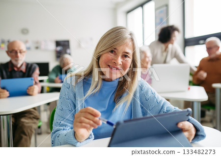 Older woman learning digital skills during course at community center. 133482273