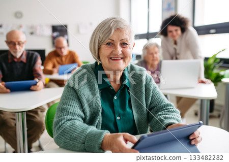 Older woman learning digital skills during course at community center. Older woman learning digital skills during course at community center. 133482282