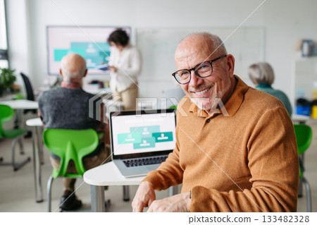 Senior man learning digital skills in community center. 133482328