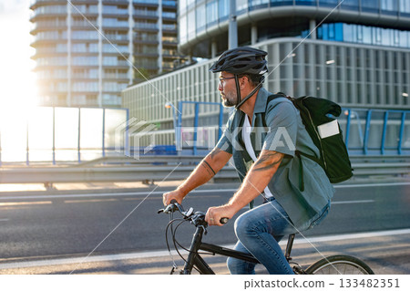 Male cyclist riding bike down the street. Male cyclist riding bike down the street. 133482351