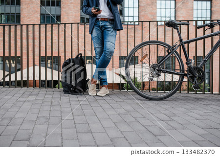 City commuter riding bike from work, reading text message on phone. City commuter riding bike from work, reading text message on phone. 133482370