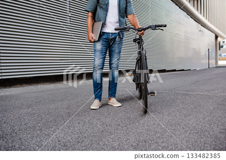 Man riding bike to work in city with helmet and backpack Man riding bike to work in city with helmet and backpack 133482385