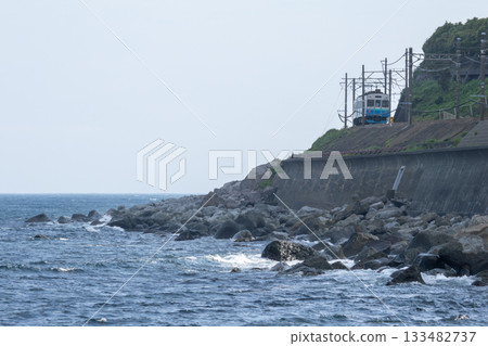 A local train running along a cliff 133482737