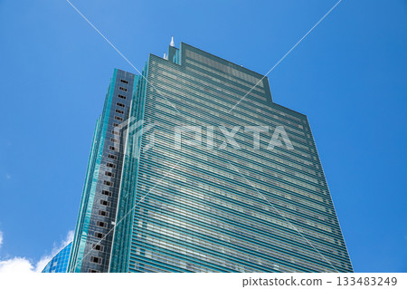 Modern glass tower skyscraper on blue sky, view from below. geometric design and contemporary building Modern glass tower skyscraper on blue sky, view from below. geometric design and contemporary building 133483249