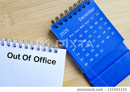 Out of office text on white notepad with blue December calendar. Christmas Celebration. Holiday season concept. 133483316