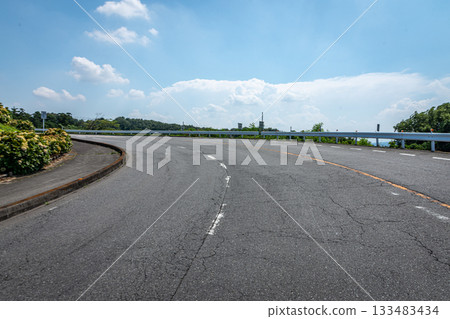 群馬縣前橋市,一條蜿蜒的車道,沐浴在湛藍的夏日天空下。 群馬縣前橋市,一條蜿蜒的車道,沐浴在湛藍的夏日天空下。 133483434