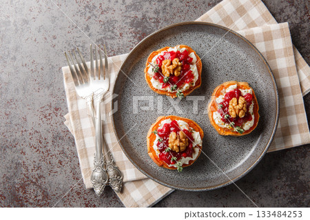 Healthy holiday food sweet potato with cream cheese, cranberry sauce, thyme and walnuts close-up in a plate. Horizontal top view Healthy holiday food sweet potato with cream cheese, cranberry sauce, thyme and walnuts close-up in a plate. Horizontal top view 133484253