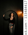 Woman in Black Top Standing by Archway with Soft Expression 133484417