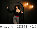 Woman Posing in Archway with Vintage Lighting 133484418
