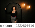 Woman in Black Top Standing by Archway with Soft Expression 133484419
