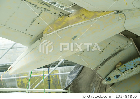 Repair work on the tail wing of an aircraft during maintenance at an airport facility early in the morning Repair work on the tail wing of an aircraft during maintenance at an airport facility early in the morning 133484810
