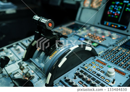 Control panel of an aircraft cockpit with various buttons, levers, and displays during a flight simulation 133484830