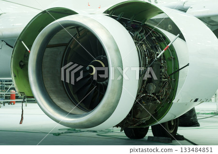 Close view of jet engine showing intricate design and engineering details in aircraft maintenance hangar during daytime Close view of jet engine showing intricate design and engineering details in aircraft maintenance hangar during daytime 133484851