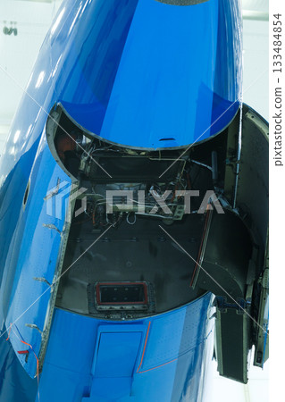 Blue airplane fuselage showing open maintenance hatch revealing technical components and wiring inside Blue airplane fuselage showing open maintenance hatch revealing technical components and wiring inside 133484854