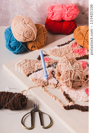 Punch needling kit, threads, canvas and needle for handmade crafts on the table vertical view 133485106