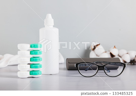 Concept of choosing between glasses and contact lenses on a table Concept of choosing between glasses and contact lenses on a table 133485325
