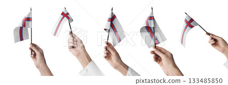The Faroe Islands flag in hand in different angles on a white background The Faroe Islands flag in hand in different angles on a white background 133485850