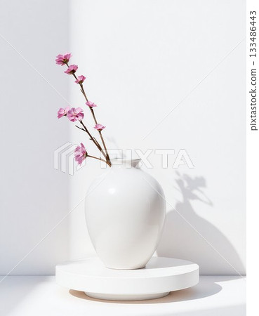 white vase with flowers on white table 133486443