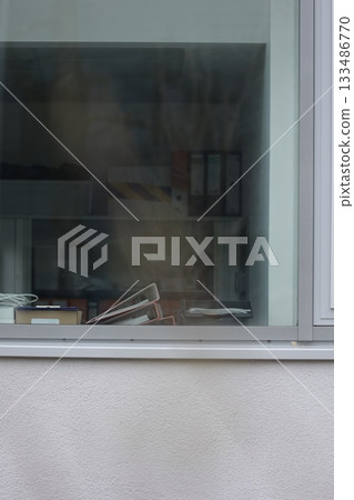 A window with a pile of papers on the sill A window with a pile of papers on the sill 133486770