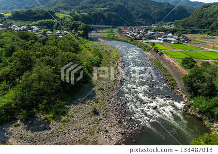 群馬縣利根川清澈的河水和湍急的河水,以及河岸和村莊的夏季景色 群馬縣利根川清澈的河水和湍急的河水,以及河岸和村莊的夏季景色 133487013
