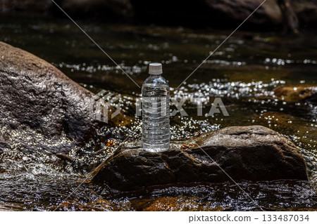 A plastic bottle placed on a rock in a clear stream, natural water and a refreshing feeling A plastic bottle placed on a rock in a clear stream, natural water and a refreshing feeling 133487034