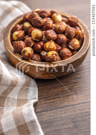 Peeled hazelnut kernels in bowl on wooden table. Peeled hazelnut kernels in bowl on wooden table. 133487091