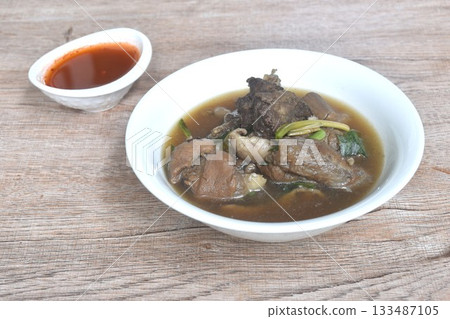 boiled braised beef meat and tendon couple organ in herb brown soup on bowl dipping spicy chili sauce  133487105
