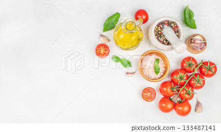 Fresh cooking ingredients with tomatoes, basil, garlic, olive oil and spices on white background, top view, copy space Fresh cooking ingredients with tomatoes, basil, garlic, olive oil and spices on white background, top view, copy space 133487141
