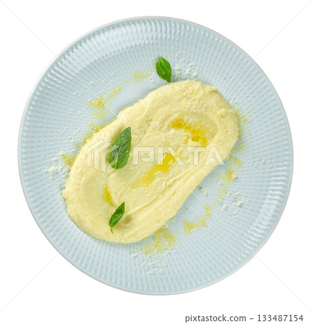Creamy mashed potatoes with parmesan and basil leaves on a light plate, top view, isolated on white 133487154