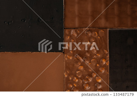 Assorted chocolate bars in a geometric layout featuring dark, milk, and nut-filled textures, perfect for confectionery branding, packaging design, and dessert advertising backgrounds 133487179